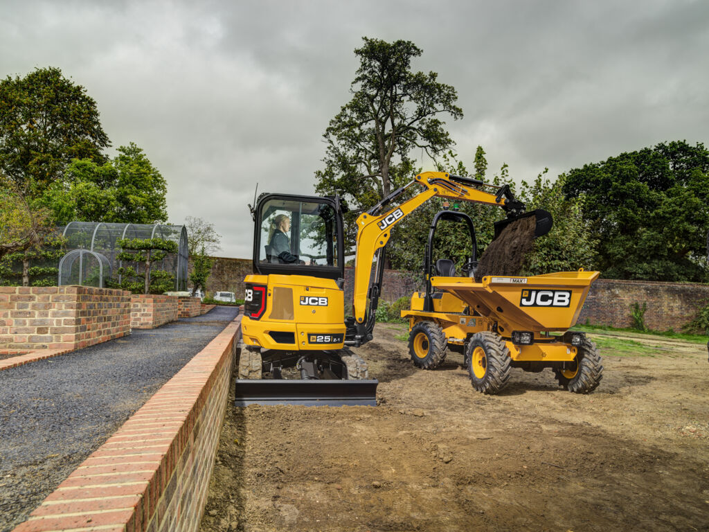 Photo mini pelle jcb vue de profil au déversement godet dans dumper JCB